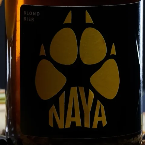 Etiket van Naya met een gouden wolvenpoot op een zwarte achtergrond