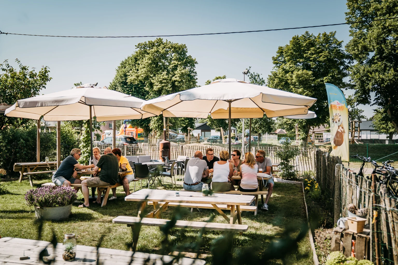 Gasten onder de parasols op het fietsterras van Brouwerij De Logt