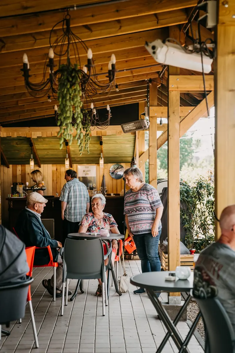 Overdekt terras met kroonluchter en gasten