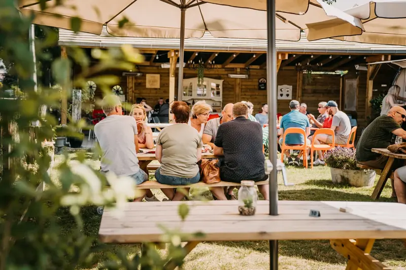Gasten onder de parasols op het terras