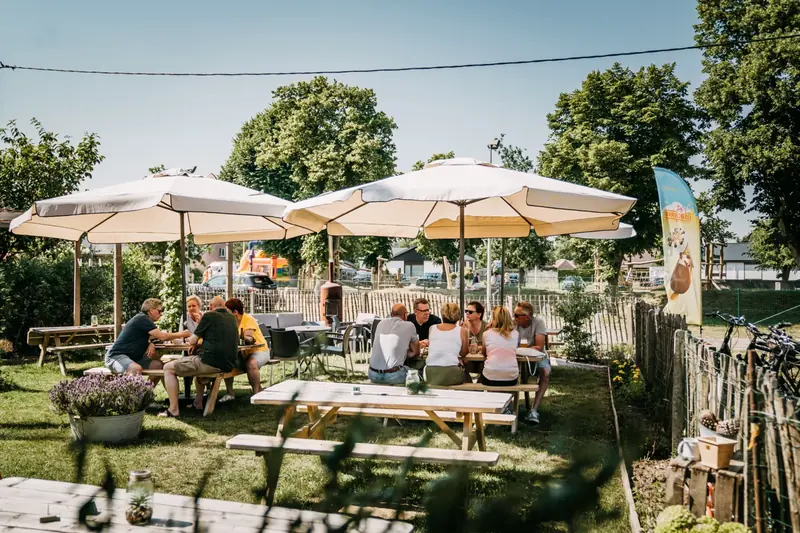 Zonnig terras met parasols en picknicktafels